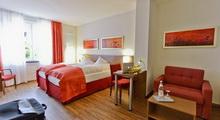 Kamer in Hotel Klostergarten met rode accenten.